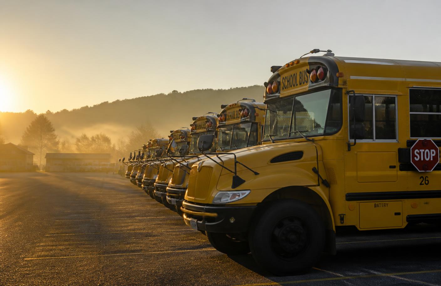 School buses lined up at sunrise before morning routes